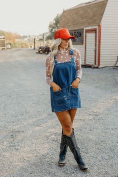 Introducing the must-have for any wardrobe: The Etta Dress. Made with durable denim and a boxy silhouette, this overall mini dress features a square neckline and detachable (and adjustable!) straps for ultimate style and comfort. The slightly distressed finish and western-inspired seam detail add a touch of unique flare. Courtney is wearing size small paired with the Daisy Mesh Top, American Cowgirl Trucker and Ariat Casanova Boots Cowgirl Birthday Party Outfit Women, Country Boot Outfits Women, Blue Jean Ball Outfit, Country Concert Attire For Women Over 40, Western Boho Dress Outfit, Blue Jean Dress With Boots, Country Cute Outfits, Fall Denim Dress Outfit, Western Overalls Outfit