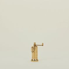 a gold colored soap dispenser is shown against a white background with no one around it