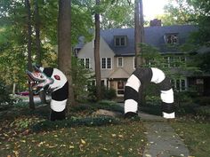 two inflatable pandas are standing next to each other on the grass outside of a house