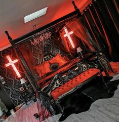 a bedroom with red lights and crosses on the wall above the bed is decorated in gothic style