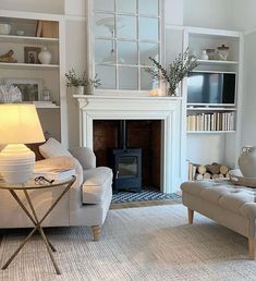 a living room filled with furniture and a fire place next to a book shelf full of books