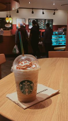 a starbucks drink sitting on top of a wooden table