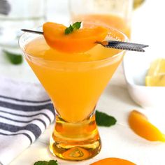 a glass filled with orange juice and garnished with mint