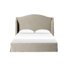 an upholstered bed with white sheets and pillows