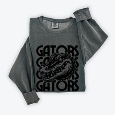 Gators Sweatshirt, Comfort Colors, Gators Mascot, Gators Shirt, Back to School, retro Gators Graphic, Gators Football, Gators Gameday, Go Gators, First Day of School, Fall Sweatshirt, Gators Merch, Gators Team Luxurious comfort and style are what this unisex, garment-dyed sweatshirt is all about. It's made with 80% ring-spun cotton and 20% polyester and the fabric is 3-end garment-dyed, ring-spun, color-blast fleece with a 100% cotton face. Each sweatshirt comes with a relaxed fit, a rolled-forw Retro Screen Print Tops For Fan Gear, Vintage Crew Neck Tops For Fan Gear, Black Retro Top For Game Day, Vintage Crew Neck Tops For Sports Events, Screen Print Crew Neck Top For Sports Events, Crew Neck Top With Screen Print For Sports Events, Vintage Fan Gear Tops With Crew Neck, Vintage Screen Print Tops For Fan Gear, Vintage Screen Print Tops For Fans