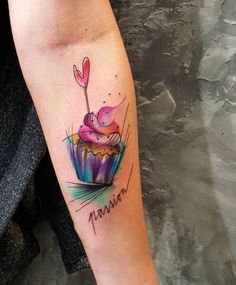 a colorful cupcake tattoo on the arm