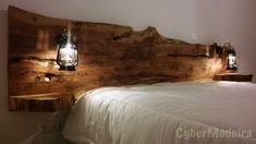 a bed made out of wood with two lights on the headboard