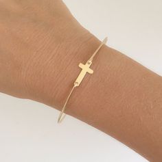 14k Gold Filled Cross Bracelet -- A 14k gold filled cross charm will be transformed into a sideways gold cross bracelet with a 14k gold filled bangle band.Also available in sterling silver.Please specify size in notes to seller during checkout... Choose from one of my regular sizes below by measuring one of your favorite bangles, or give me the circumference of the widest part of your hand where the bangle has to be pulled over; then I can size your side cross bracelet for you. All of my bangles Confirmation Jewelry, Silver Cross Bracelet, Moon Bracelet, Bracelet Women, Bracelet Online, Cross Bracelet, Cross Jewelry, Sterling Silver Cross, Gold Cross