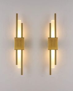 two gold wall lights on a white wall