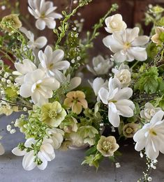 a bunch of white flowers sitting on top of a cement floor next to each other