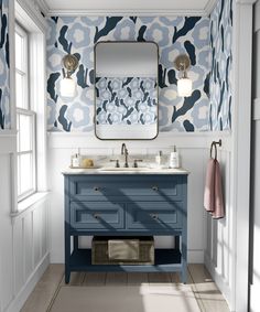 a bathroom with blue and white wallpaper, two sinks and a large mirror on the wall