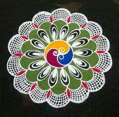 a white doily with a red, yellow and green flower on it