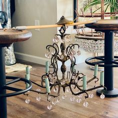 a chandelier hanging from the ceiling in a room with wooden floors and chairs