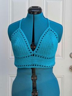 Medium handmade crochet top with lace-up back in aqua. 100% cotton. Measurements: Bottom Band  Length - 24" Bottom Band Height - 3" Cup Height (excluding bottom band) - 7" Cup Width (each) - 7.5" For best care, hand wash or machine wash with cold water in delicates bag on a gentle cycle and lay flat to dry. Made from Lilly pattern by Kelsie at PassioKnit Goods, passioknitgoods.com. Cotton Crochet Top With Crochet Trim For Beach Season, Cotton Crochet Top With Trim For Beach Season, Cotton Crochet Lace Top For Beach Season, Blue Cotton Crochet Lace Top, Blue Cotton Crochet Top For Festival, Crochet Lace Triangle Top For Beach, Triangle Top Crochet Lace Beach Tops, Beach Triangle Top With Crochet Lace, Triangle Top With Crochet Trim For Beach