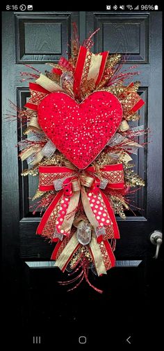 a red and gold heart wreath on a black door