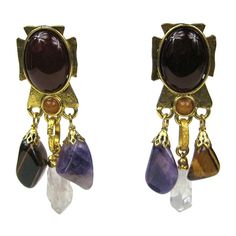 Philippe Ferrandis Stone Bronze Amethyst Quartz and Tigers eye Earrings Clip on's. Measure 3.22 inches Long x 1 inches wide as it sits on your ear. Cross-shaped on the metal earring, with an amber-colored Stone center. Truly a work of art, Circa 1990′s. Purchased and never worn as is with about 90% of our costume jewelry. Philippe Ferrandis is an internationally renowned, French jewelry designer with over 25 years of dedicated work in his chosen art form. He is widely recognized in the couture w Purple Chandelier, Purple Amethyst Earrings, Tiger Eye Earrings, Earrings Chandelier, Stone Dangle Earrings, Earrings Purple, Long Dangle Earrings, Couture Jewelry, Amethyst Jewelry