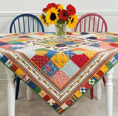 a table topped with a vase filled with sunflowers