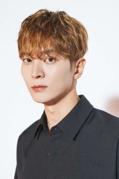 a young man with brown hair wearing a black shirt