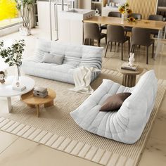 a living room filled with furniture next to a dining room table and chairs on top of a rug