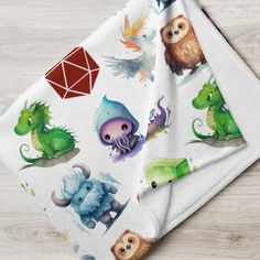 three napkins with animals on them sitting next to each other in front of a wooden table