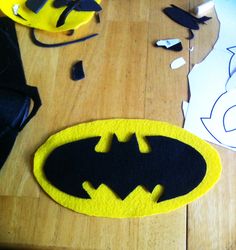 the batman symbol is cut out from felt and placed on a wooden table with construction tools