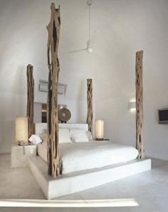 a bed made out of wood sticks in a room with white walls and flooring