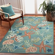 a blue rug with starfishs and shells on it in front of a door