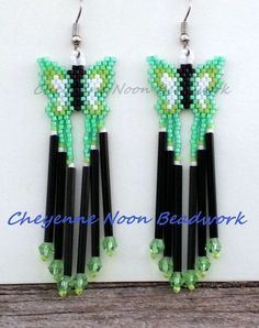 the earrings are made with black, green and white beaded beads that have flowers on them