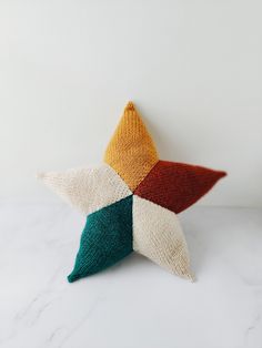 a multicolored star pillow sitting on top of a white counter