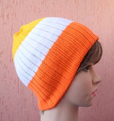 a mannequin head wearing an orange, white and yellow knitted beanie