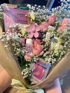 a bouquet of flowers and baby's breath are wrapped in tissue paper on a table