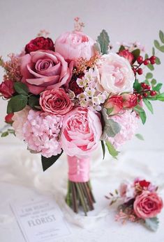 a bouquet of pink flowers sitting on top of a table