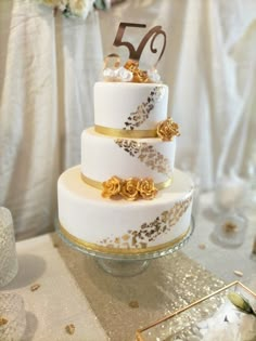 a white and gold wedding cake on a table