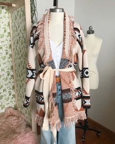 A stunning knit blanket sweater that is perfectly cozy for the season. Open front & soft fringe fold over collar. Color: Cream, camel & black Poly Hand wash cold Model is a size 8 wearing a medium. Small Medium Large Bust 50 52 53 Waist 49 51 52 Hips 51 53 54 Length 31 31 31 Bust, waist, and hip measurements are a total circumference. Length is measured from the top of the shirt to the hem. Measurements are an estimate. Shawl Collar Sweater Coat For Cold Weather In Fall, Beige Shawl Collar Sweater Coat For Fall, Shawl Collar Sweater Coat For Fall, One Size Fringe Sweater For Fall, Knit Outerwear With Fringe For Fall, Knit Fringe Outerwear For Fall, Bohemian Knit Sweater Coat For Fall, Cozy Shawl Collar Sweater For Fall, Camel Long Sleeve Sweater For Fall