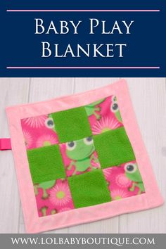 the baby play blanket is made from pink and green squares with an image of a frog on