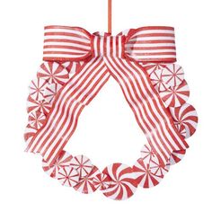 a red and white christmas wreath hanging from a string with candy canes on it