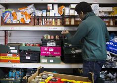 a man standing in front of a store shelf filled with boxes and food items on shelves