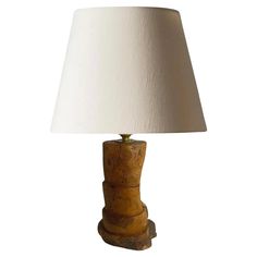 a wooden table lamp with a white shade on the top and bottom part of it