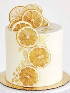 there is a white cake with orange slices on the top and gold trimmings