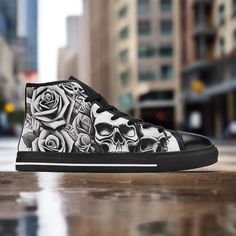 a pair of black and white high top sneakers with skulls and roses painted on them