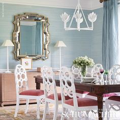 a dining room with blue walls and white furniture