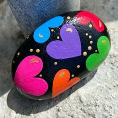 a painted rock with hearts on it