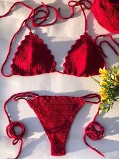 two pieces of red crochet swimsuit with flowers on top and white background