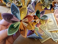 a person is holding money and origami flowers