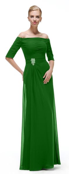 a woman in a green dress posing for the camera with her hands on her hips