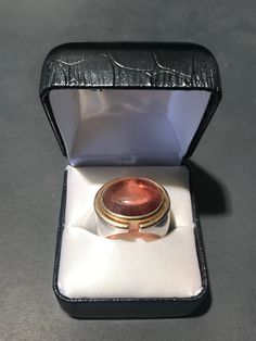 Beautiful custom made Pink Champagne Tourmaline Stone, with 18k gold and sterling silver ring. Very substantial one of one piece- a show stopper. We purchased this piece as part of a jewelry collection in London, UK. Origin: London, UK Period: 1970 - 1979 Condition: Good, not brand new or in flawless condition- there is wear to the metals and stone. A choice piece. US Ring Size: US 8 * Complimentary shipping to Continental US. * Our Guarantee: Items purchased online will arrive as described. Unique Cabochon Ruby Ring For Formal Occasions, Polished Tourmaline Ring As Gift, Polished Tourmaline Rings For Gift, Formal Hallmarked Tourmaline Jewelry, Luxury Polished Tourmaline Rings, Silver Tourmaline Rings For Formal Occasions, Formal Heirloom Tourmaline Jewelry, One Of One, Tourmaline Stone