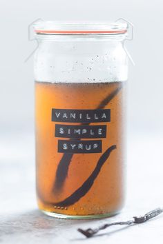 a glass jar filled with liquid sitting on top of a white table next to a pair of scissors