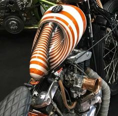 an orange and white striped motorcycle parked next to other motorcycles