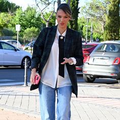 a woman is walking down the street with her hand in her pocket