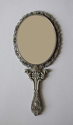 the mirror is hanging on the wall and has an ornate design around it's edge